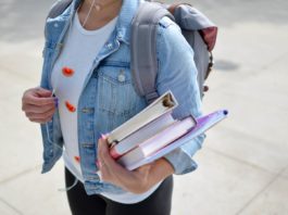 Une jeune étudiante tenant des livres sous le bras