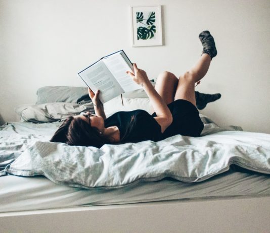 Une jeune fille sur son lit en entrant de lire (Paderborn, Allemagne).