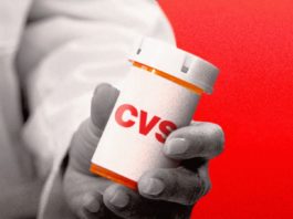 Un medecin présentant une boîte à comprimés CVS.