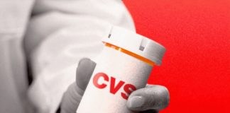 Un medecin présentant une boîte à comprimés CVS.