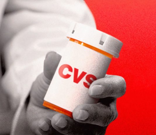 Un medecin présentant une boîte à comprimés CVS.