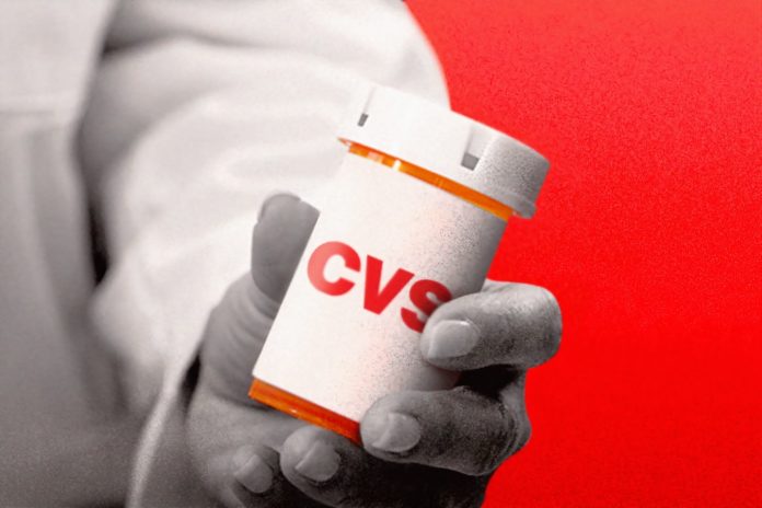 Un medecin présentant une boîte à comprimés CVS.