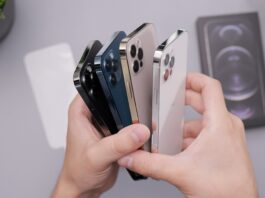 Une personne tenant plusieurs iPhone 12 en main.